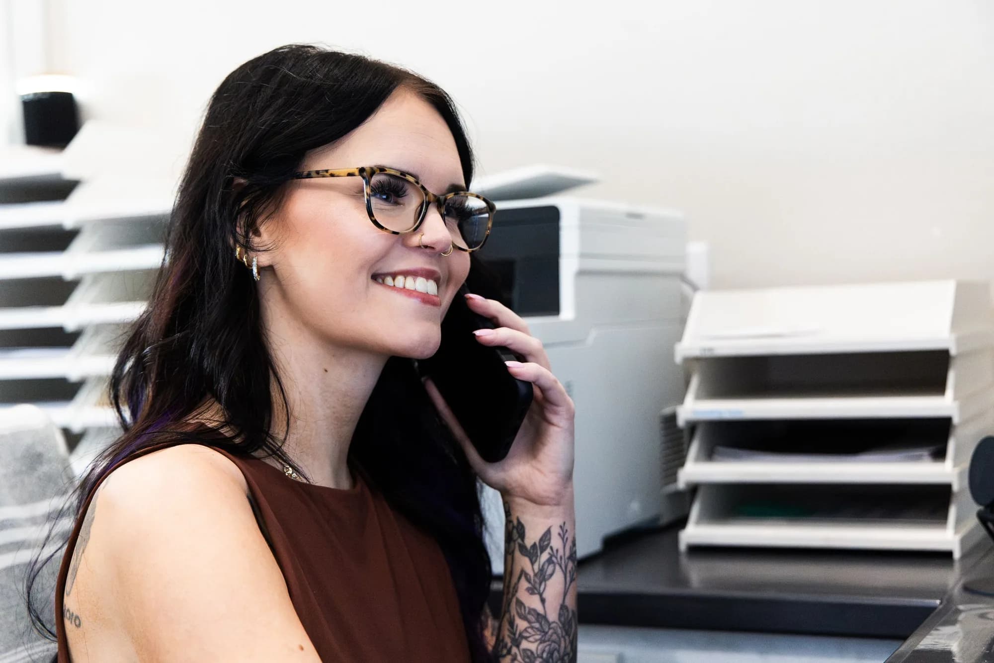 Office team member smiling while taking a call at the CC Garage Door front desk