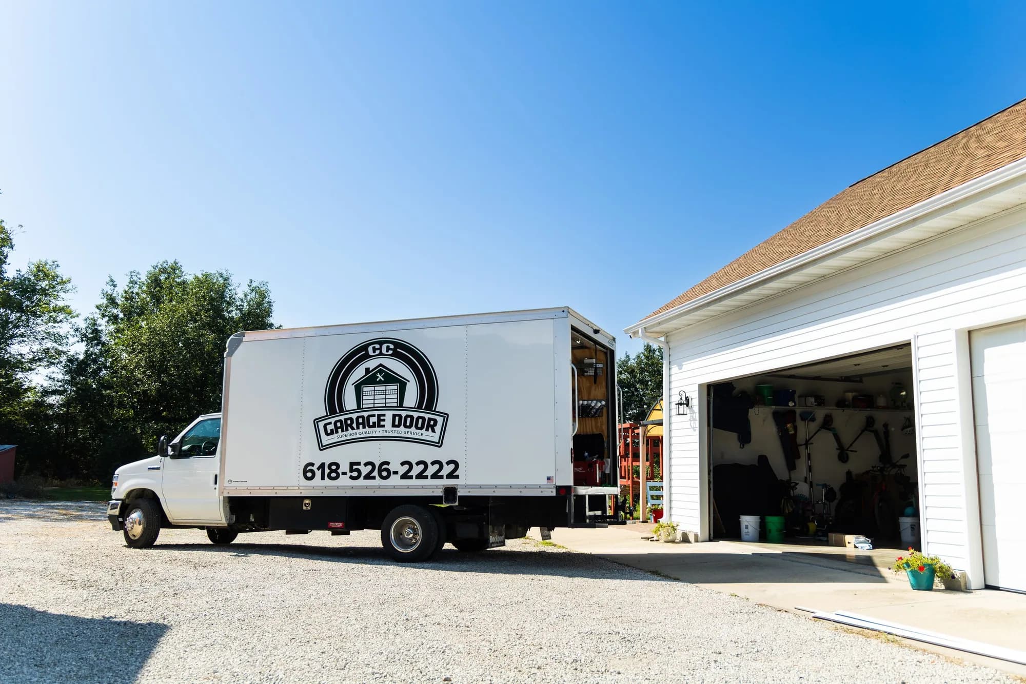 CC Garage Door service truck parked at a home with the garage door open