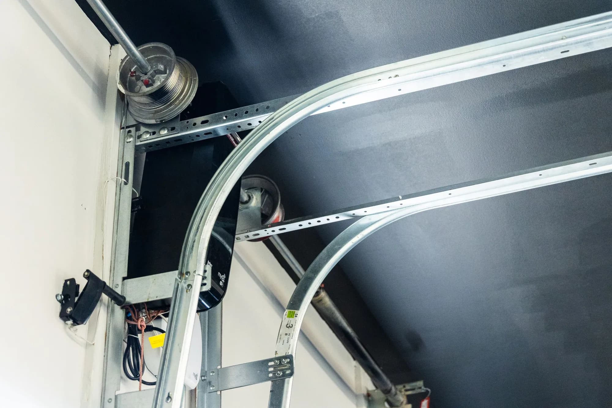 Garage door rollers riding in the curved track where it meets the horizontal rail